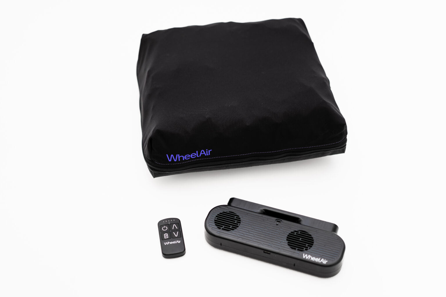 The WheelAir system is placed on a white background, including a wheelchair cushion cover, a small black remote control, and the double fan encased in a black housing.